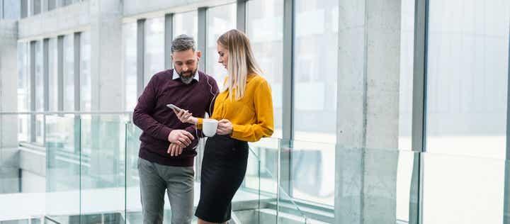 two sales professionals looking at a the status of an account on their phone, excited to see the progress they're making because of the skills they built in the prosperous account strategy training program