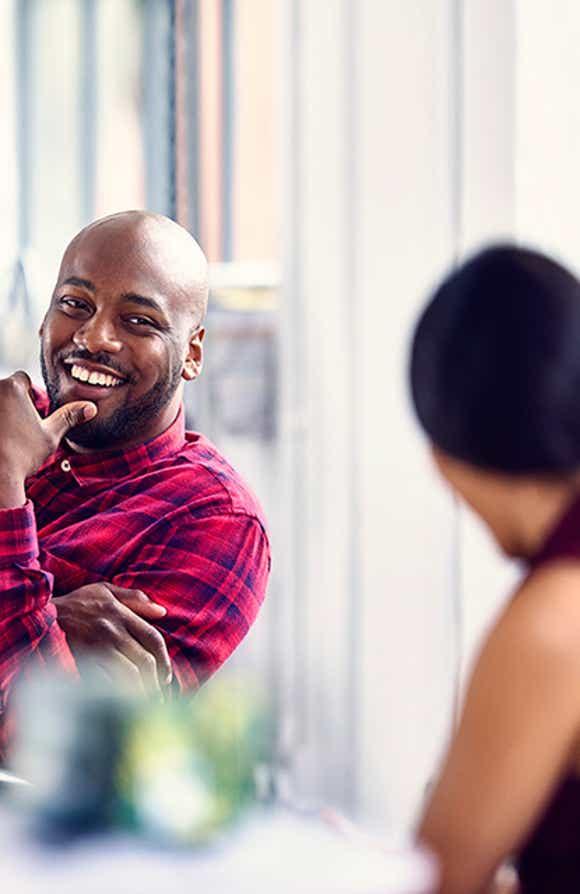 two sales professionals sitting at a desk looking happy because they have the soft selling skills they need to succeed thanks to richardson's six critical skills training program